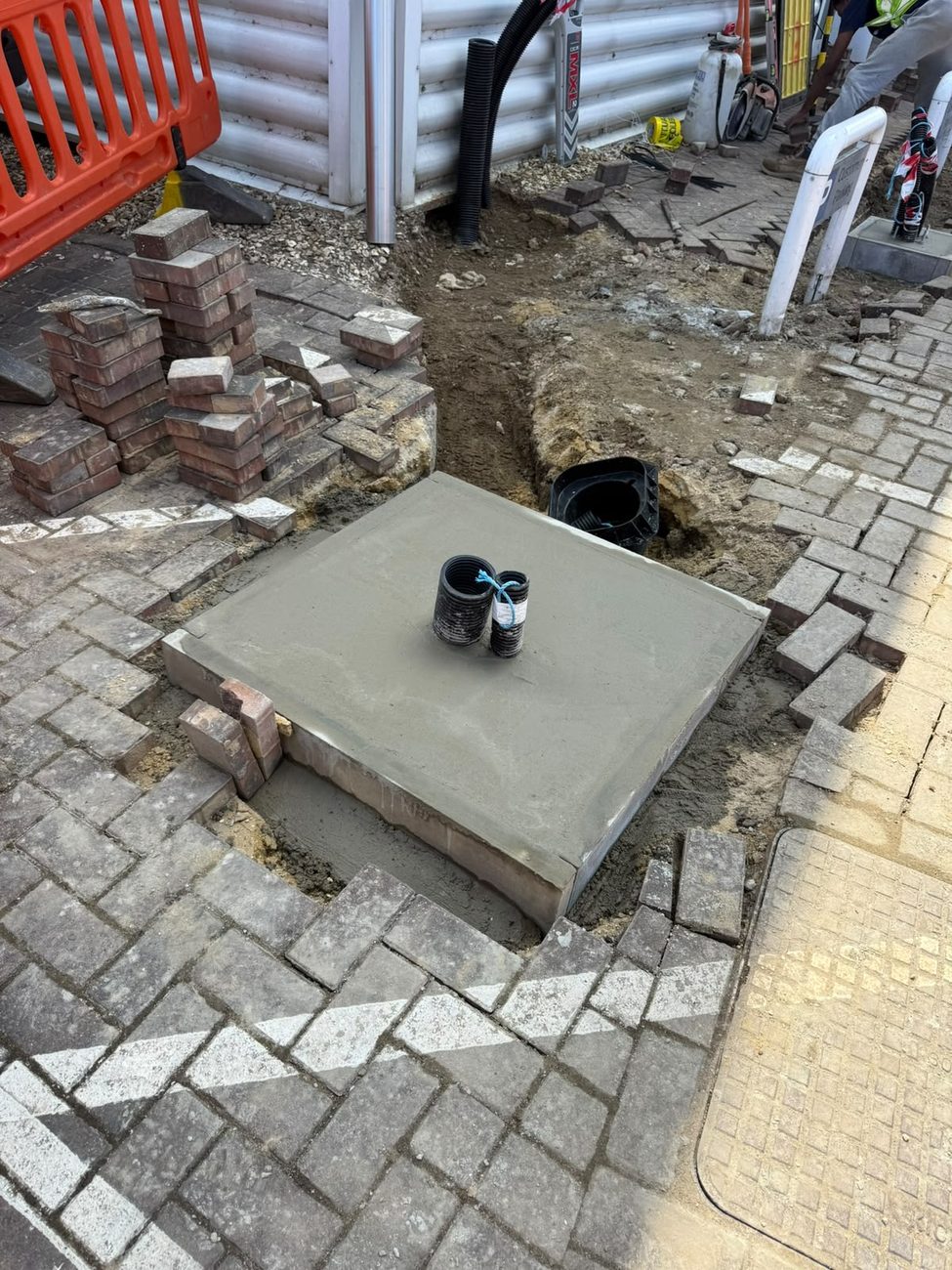 Concrete base and reinstated paving for an EV charger